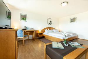 SteinenHotel Landgasthof zum Pflug的酒店客房配有一张床铺和一张桌子。