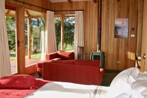 瓜达尔港Lodge El Mirador De Guadal的一间卧室配有一张床、一张沙发和一个壁炉