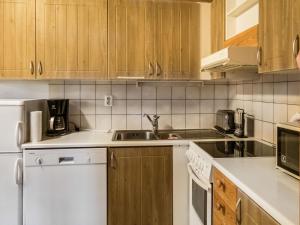 拉赫登佩拉Holiday Home Vuokatinportti a7 by Interhome的厨房配有白色家电和木制橱柜