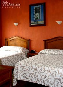 特拉科塔尔潘Hotel Posada Doña Lala的卧室配有两张床,墙上挂着一幅画