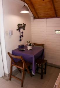 塔菲德尔瓦勒Cabañas La Maria Lourdes的一张桌子,上面有紫色的桌布和鲜花