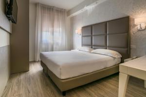 福尔米吉内葛罗波酒店的卧室设有一张白色大床和一扇窗户。
