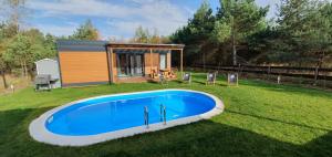 PrażmowoPrażmowo 49的一座小房子,在院子里设有一个游泳池