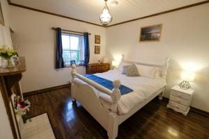韦斯特波特The Cottage Hillside的卧室配有白色的床和窗户。