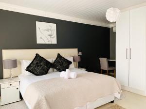 乌姆塔塔Resthaven Guest House的卧室配有一张白色的床和黑色的墙壁