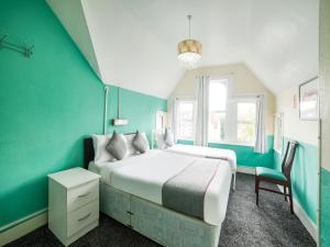 滨海绍森德OYO Devine Beach Hotel, Westcliff Southend-On-Sea的一间卧室设有两张床和绿色的墙壁