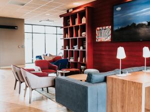 鲁昂坎帕尼尔罗恩梅尔莫兹旅馆的大堂配有沙发、椅子和电视
