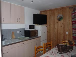 Crévouxla grange的一个带水槽的厨房和墙上的电视