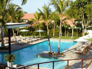拉罗马纳坎普之家别墅度假酒店的一个带椅子和遮阳伞的游泳池以及棕榈树