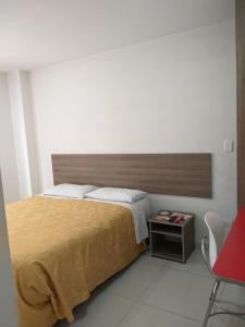 波哥大A Bogota On Holidays by Open - HOTEL的一间卧室配有一张大床和一张红色椅子