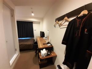 伊万里市HOTEL WIN的客房设有带书桌和床的卧室。