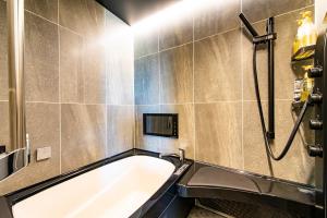 伊万里市HOTEL WIN的一间带浴缸和淋浴的浴室