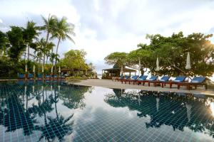 查汶查汶海滩度假酒店的度假村的游泳池,带躺椅和树木