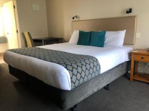 但尼丁555 Motel Dunedin的一间卧室配有一张带蓝白色枕头的大床