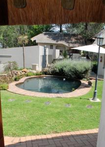 莱迪史密斯Buller's Rest Guest Lodge的庭院里的一个小游泳池,配有遮阳伞
