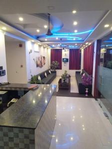 KushinagarHotel the Ideal的带沙发和酒吧的大型客厅