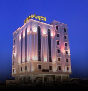 吉赞Quba Inn Hotel的上面有 ⁇ 虹灯标志的建筑
