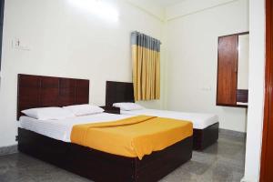 科钦Jippus Galaxy Budget Air port hotel的一间卧室,配有两张床