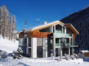 萨姆瑙恩Alpinlodge & Spa的雪中带滑雪缆车的房子