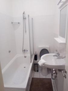 威廉港Boardinghouse Wilhelmshaven的白色的浴室设有浴缸和水槽。