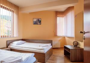 切佩拉雷罗多彼旅馆的一间卧室设有两张床、一张桌子和窗户。