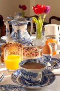 锡辛赫斯特Sissinghurst Castle Farmhouse的一张带蓝白花瓶的桌子和一杯咖啡