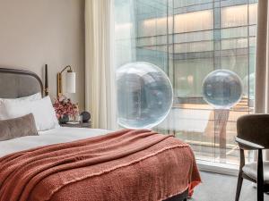 伦敦The Stratford Hotel London的一间卧室设有一张床和一个气泡窗户