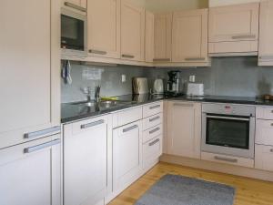 KukkolaHoliday Home Suvela by Interhome的厨房配有白色橱柜和不锈钢用具