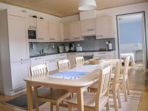 KukkolaHoliday Home Suvela by Interhome的厨房配有白色橱柜和桌椅