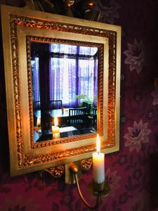 VejbystrandVejbystrands Vandrarhem的一面墙上的镜子,前面有蜡烛