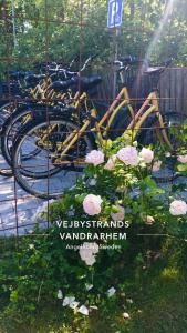 VejbystrandVejbystrands Vandrarhem的一辆自行车停在玫瑰花标志旁边