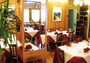 普雷圣迪迪埃布卡奈维酒店的餐厅配有桌椅和红色餐巾