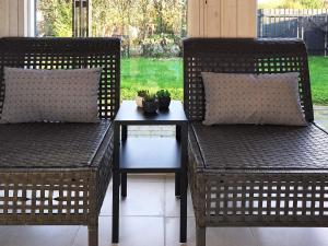 森讷比9 person holiday home in Juelsminde的两把藤椅和一张桌子与植物