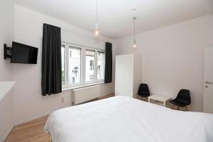弗尔内Loft vakantiehuis的卧室配有白色的床和窗户。
