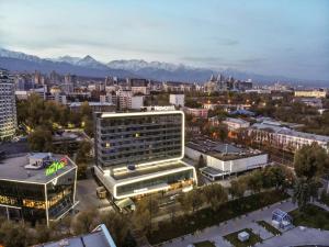 阿拉木图Novotel Almaty City Center的享有拥有建筑和山脉的城市美景