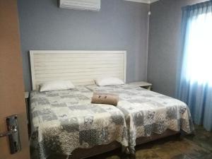 赫卢赫卢韦Umsinsi Cottage的一间卧室配有一张带枕头的床