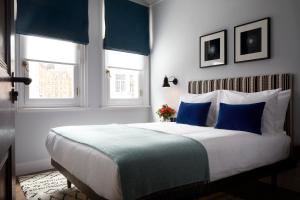 伦敦The Coach的一间卧室配有一张带蓝白色枕头的大床