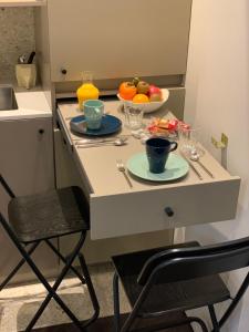 巴黎PARIS RIVOLI NOTRE DAME Chambre d'Hôtes Studio Private的小厨房配有带一碗水果的桌子