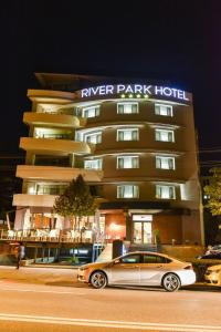 克卢日-纳波卡Hotel River Park的停在酒店前的停车场