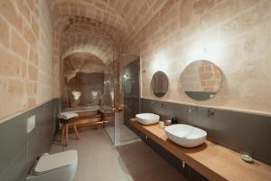 马泰拉Endea Suite Rooms & Lounge SPA的一间带两个盥洗盆和淋浴的浴室