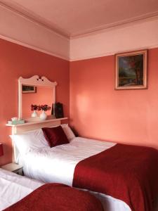 伦敦里海旅馆的一间带两张红色墙壁床铺的卧室
