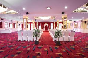 曼彻斯特曼联萨斯酒店的宴会厅配有白色椅子和红地毯