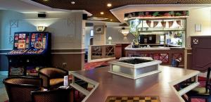 考文垂大不列颠考文垂酒店的一间酒吧,里面配有桌子和机器