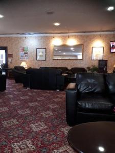 考文垂大不列颠考文垂山酒店的一间设有黑色皮革家具和镜子的等候室