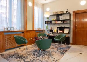 博洛尼亚马焦雷酒店 的客厅配有绿色椅子和桌子