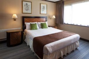 克劳利盖特威克欧罗巴酒店及Spa的酒店客房配有一张带绿色枕头的大床