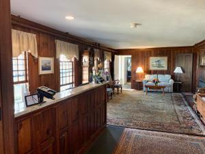 西丹尼斯科德角灯塔酒店的一间带木镶板的客厅和一间带沙发的客厅