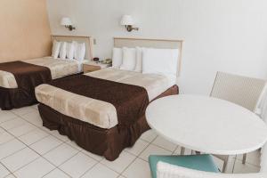 怀尔德伍德Heart of Wildwood Motel的酒店客房设有两张床和一张桌子。