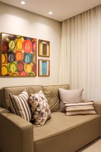 萨尔瓦多FANTÁSTICO APARTAMENTO NA BARRA的客厅的沙发,配有绘画作品