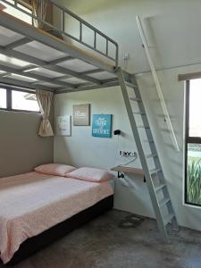 马六甲Orchard Villa Melaka的一间卧室设有双层床和楼梯。